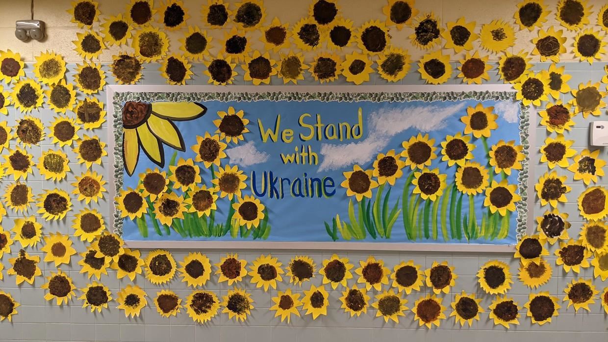  Bulletin board at Kennedy with the message of We Stand with Ukraine with sunflowers around it.